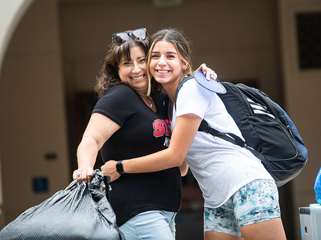 Parent and student hugging on move-in day